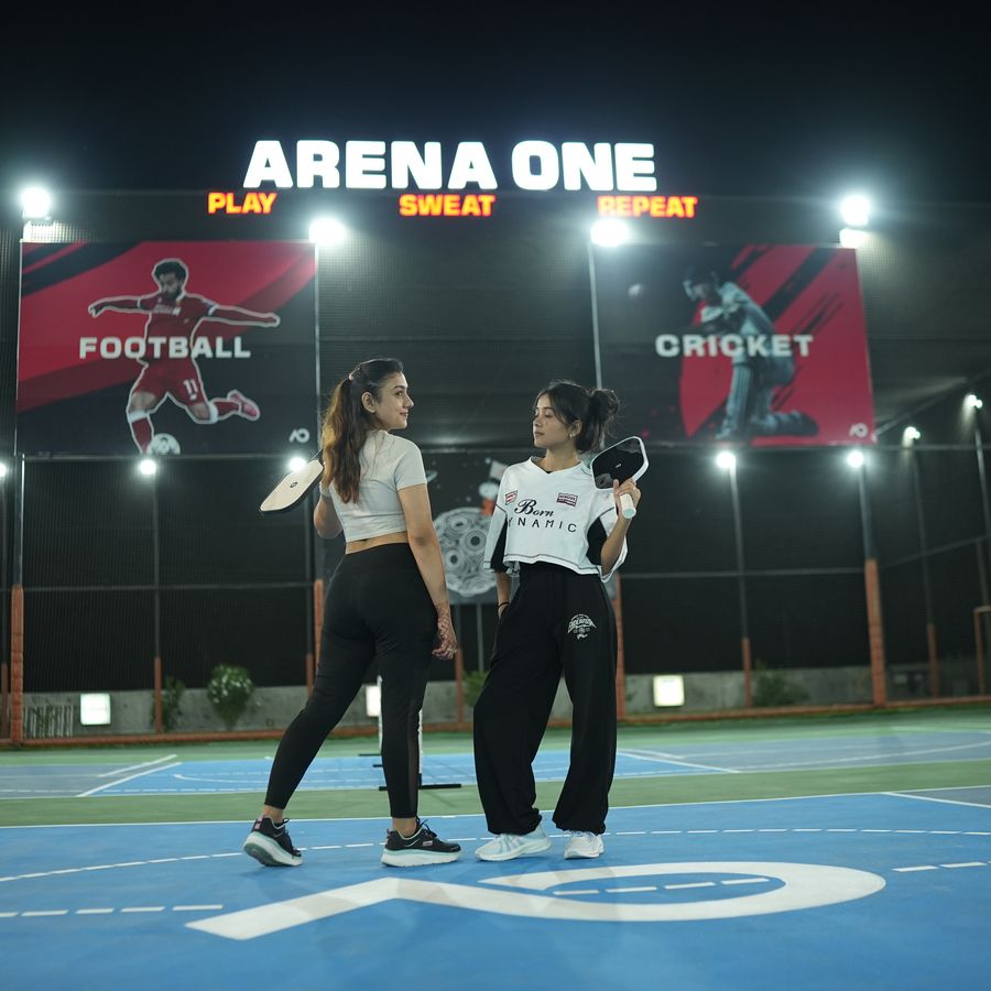 Players with pickleball paddles at Arena One at night