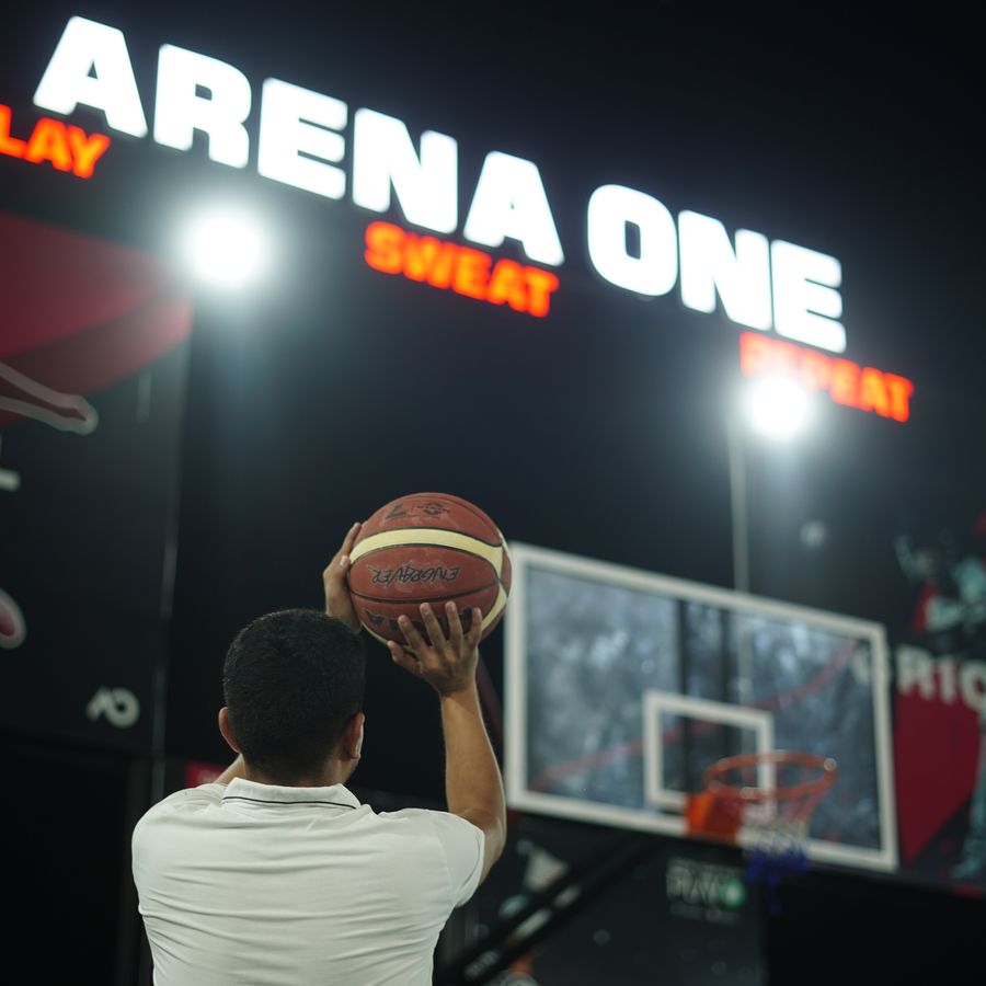 Player shooting a basketball at Arena One's hoop court